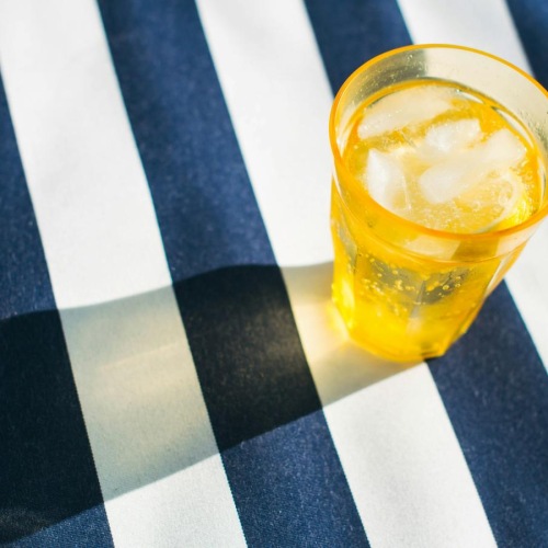 a glass of water on a striped surface
